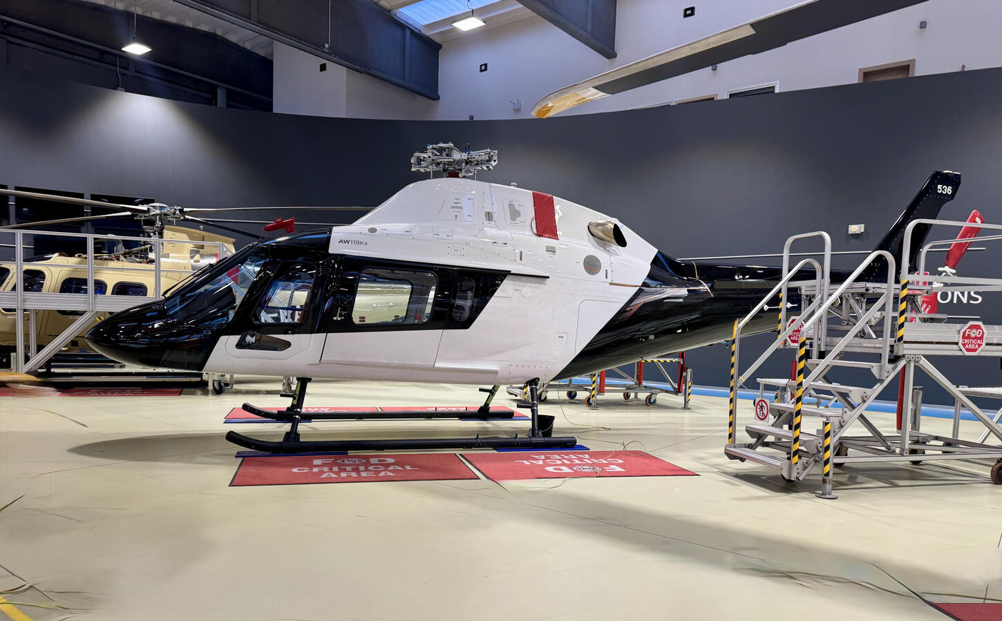 Helicopter in maintenance hangar during aircraft transition support process